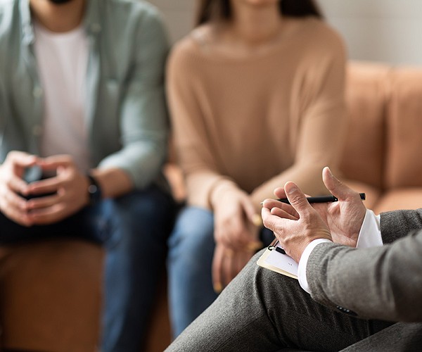 Couple talking at session with male therapist