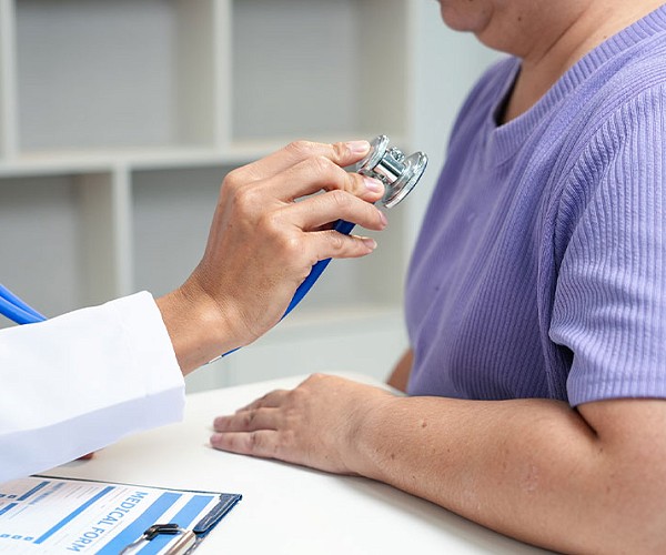 Doctor using a stethoscope to examine a patient during a medical checkup.