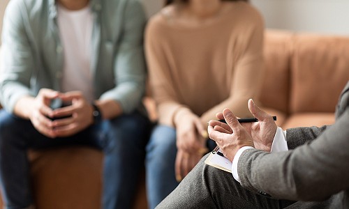 Couple talking at session with male therapist